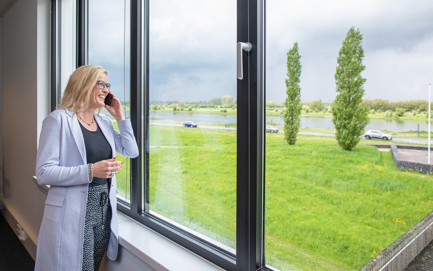 Natasja Hulsebos kijkt door het raam naar de IJssel